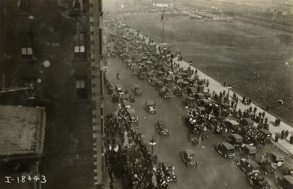 Elevated view of a parade on Michigan Avenue taken from the International Harvester building. Grant Park is in the background.