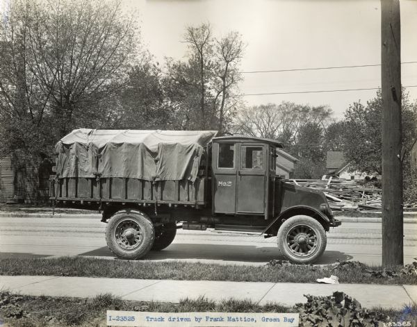 International Model G-61 truck owned by Frank Mattice parked on a residential street. Caption at bottom reads: "I-23525 Truck driven by Frank Mattice, Green Bay".