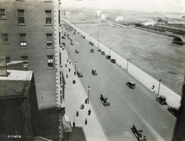 Elevated view of pedestrians and automobiles on Michigan Avenue from a window in the International Harvester building. Grant Park is across the street.