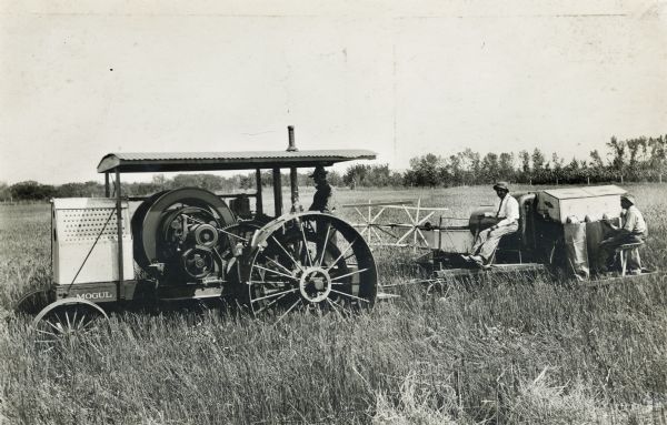 Mogul tractor pulling an experimental(?) harvester-thresher (combine) in a field.
