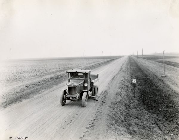 Elevated view of two men driving an International truck on U.S. Highway 75 between Breckenridge and Moorehead in Minnesota.