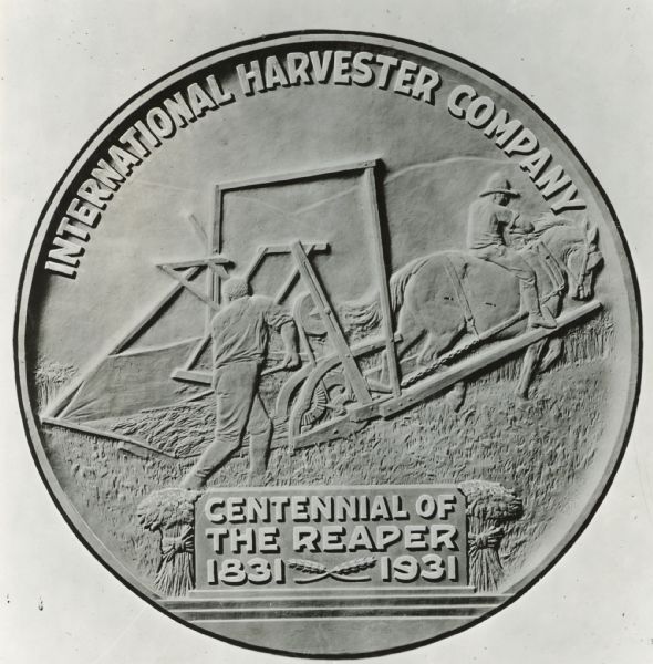 Reverse side of the International Harvester reaper centennial medallion (or coin) showing the reaper in use, and the words: "Centennial of the Reaper, 1891-1931."
