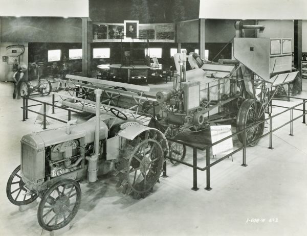 Elevated view of a McCormick-Deering 10-20(?) tractor and a harvester-thresher (combine) on display in the International Harvester exhibit at the "A Century of Progress" world's fair in Chicago. A portrait of Cyrus Hall McCormick is hanging in the background.
