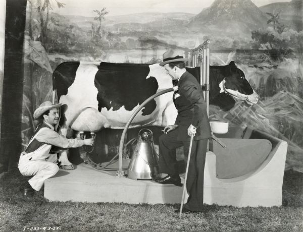 Radio stars Jack Pearl and Cliff Hal posing with a mechanical cow and milker in the International Harvester exhibit at the "A Century of Progress" world's fair.