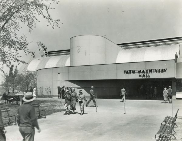 Pedestrians near the entrance to Farm Machinery Hall at the "A Century of Progress" world's fair.