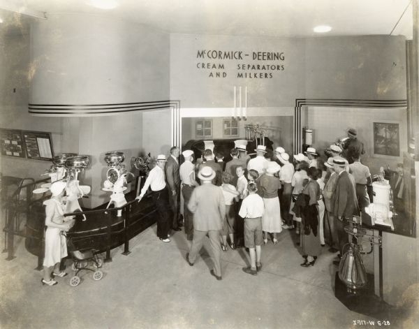 A crowd gathers around the International Harvester dairy display at the "A Century of Progress" world's fair. The display included cream separator's, mechanical milkers, and a mechanical cow.
