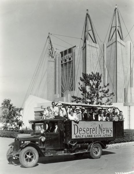 A group of young men riding in the back of an International truck used by the "Deseret News" of Salt Lake City, Utah. The truck is parked at the "A Century of Progress" world's fair.