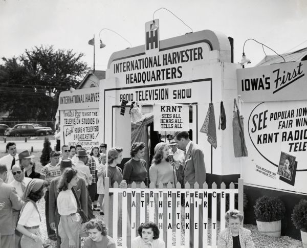 A crowd gathers around the International Harvester headquarters at the Iowa State Fair to watch a live broadcast from radio station KRNT.
