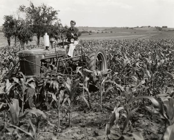 Betty Stevens, a participant in "Tractorette" class offered by the Nodaway County Implement Company, is riding a Farmall H tractor through J.D. Thompson's 47-acre cornfield.