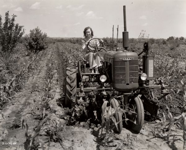 16-year-old Wanda Lee Grace, a participant in "Tractorette" class offered by the Nodaway County Implement Company, driving her father's Farmall B tractor through a field.
