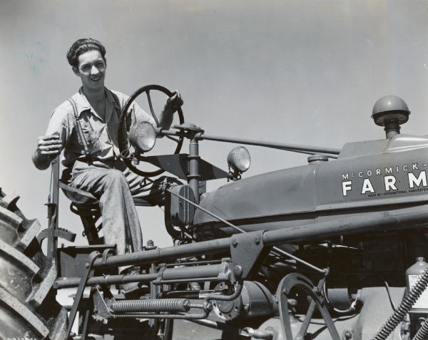 A young man operating a McCormick-Deering Farmall tractor. The photograph was taken as part of a 1946 4-H Field Corps contest.