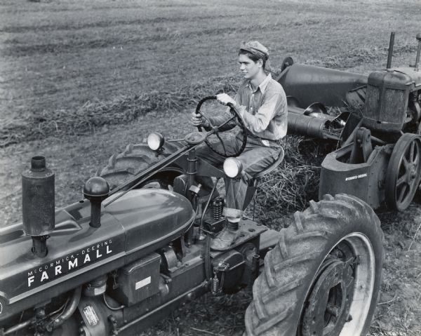 A young man operates a McCormick-Deering Farmall tractor. The photograph was taken for a 1946 4-H Field Corps Contest.