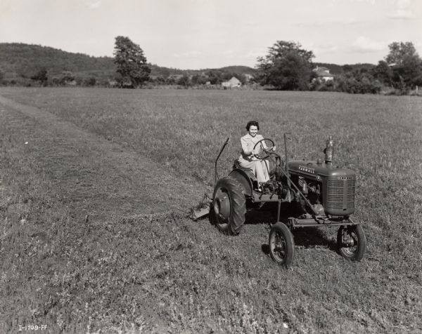 Mrs. Jesse Jones, a participant in a "Tractorette" class organized by the Blanchard Motor Company, drives a Farmall tractor on the farm of Mrs. Helen George.