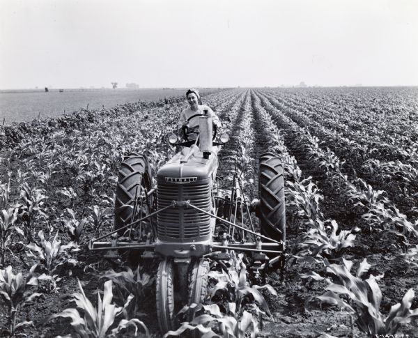 Mrs. Herbert B. Schwaller of Morning Sun, Ohio drives a Farmall tractor through a field. Mrs. Schwaller may have taken part in International Harvester's wartime "Tractorette" program.