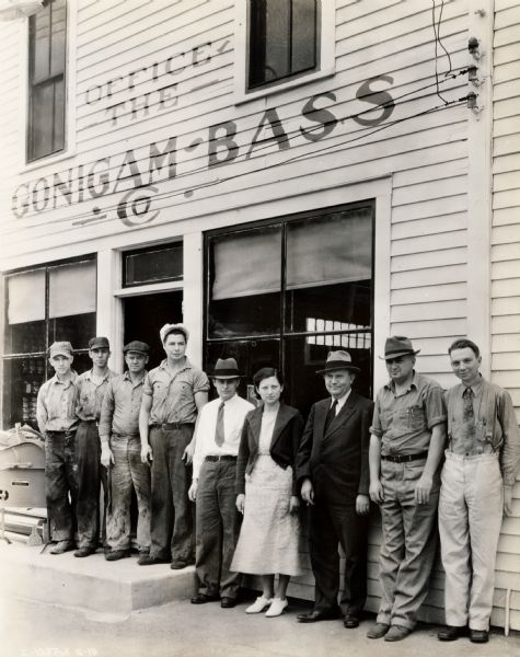 Employees stand in a line outside the Gonigam - Bass Company, possibly an International Harvester dealership.