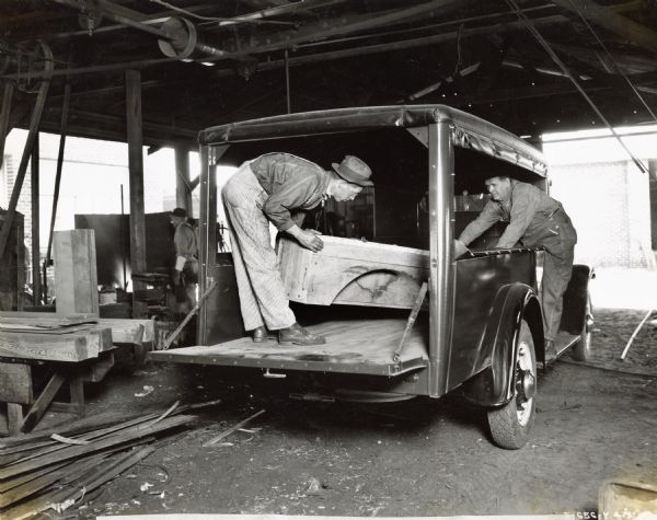 B.B. Rich, blacksmith, C.H. Rhoden, and C.H. Richardson install special cabinets in a canopy-top body of a Model C-20 International Truck for the Jacksonville City Water Works Department.