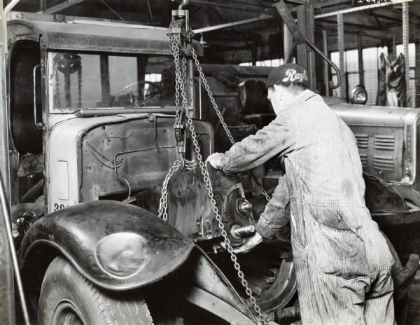 Mechanic V.E. Gibson installs an overhauled engine into an International Model A-5 truck at the City of Jacksonville Garage.