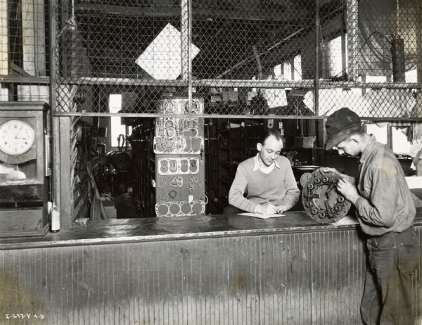 J.L. Burroughs, Jr., stock clerk, delivers an automobile part to mechanic C.H. Robbins at the City of Jacksonville Garage.