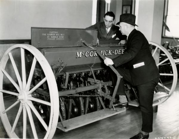 F.A. Hodsdon and Mr. Conkright inspect a McCormick-Deering steel hopper grain drill at International Harvester's Milwaukee branch house.