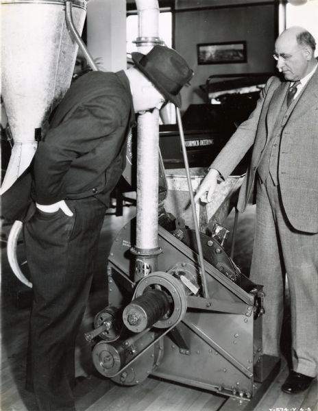 Mr. W.L. Jens, manager of International Harvester's Milwaukee branch house, and Mr. F.C. Kohlmeyer look at a No. 1-B hammer mill.