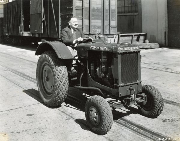 E.S. Marnon, I-12 salesman at the Howard-Cooper Corporation, rides a McCormick-Deering tractor. The Howard-Cooper Corporation was likely an International Harvester dealership.