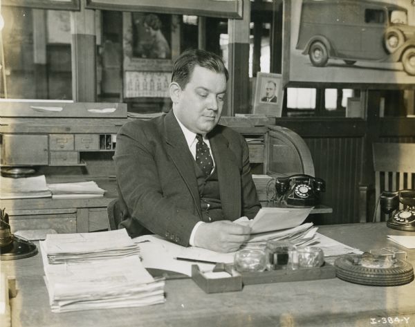 C.F. Stewart of International Harvester's Fort Wayne Works sits behind a desk in an office.