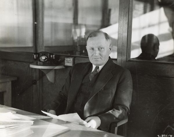 Alfred Krieg, chief engineer at International Harvester's Fort Wayne Works, sitting behind an office desk.