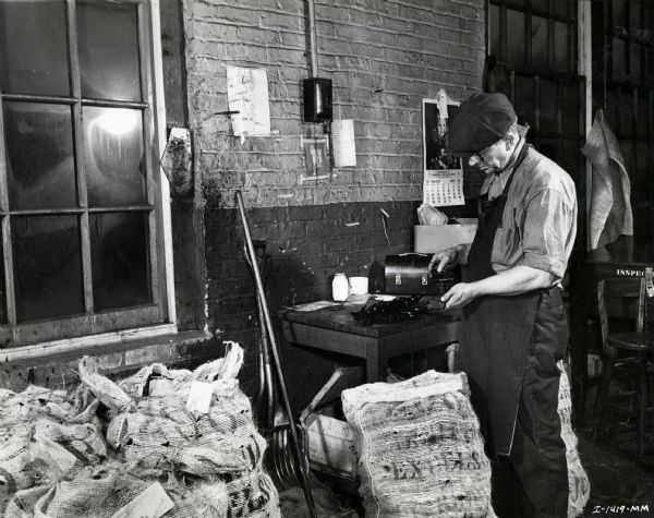 An factory worker at McCormick Works performs a final inspection of mower guards.