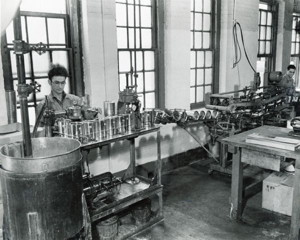 An factory worker at McCormick Works uses an automatic filling and labeling machine.