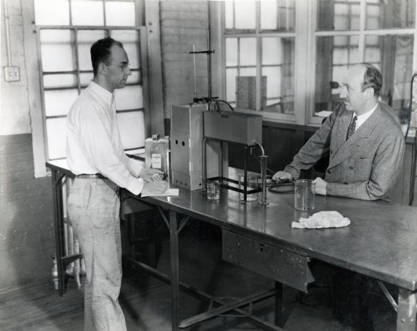 Two men determine the distillation range of paint thinner in the Paint Department of McCormick Works (factory).