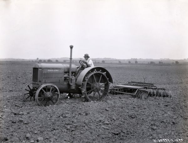 Clarence Thurow operating a McCormick-Deering tractor with a disk harrow attachment on the Col. R.R. McCormick farm [Robert Rutherford McCormick?].
