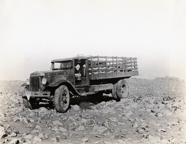 An International truck with a license plate that reads "TEST" is being driven through a rocky field.