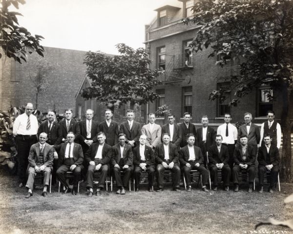 A group of 23 men from the McCormick Works Council posing for an outdoor photograph.