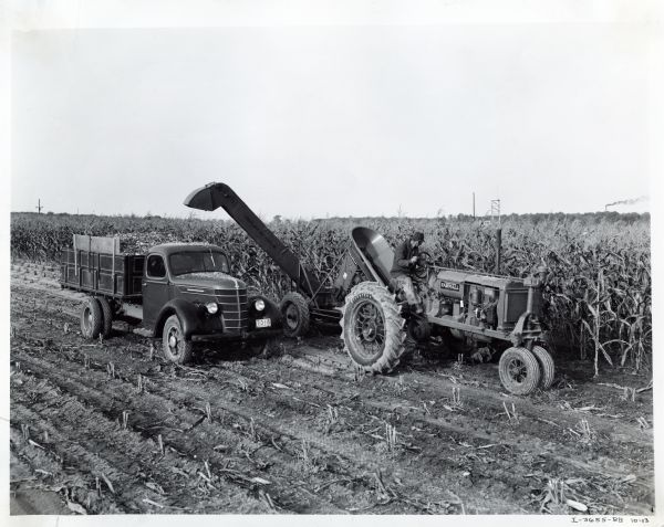 A farmer using a Farmall F-30 tractor to power a Ronning ensilage harvester on the Purdue University livestock farm.