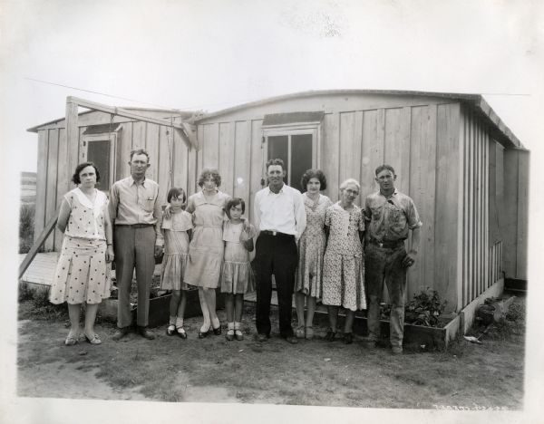 The C.M. Jeffries family poses for a portrait outside a small building.