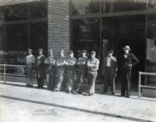 Employees of the Delta Implement Company, an International Harvester dealership, lined up outdoors for a group portrait.