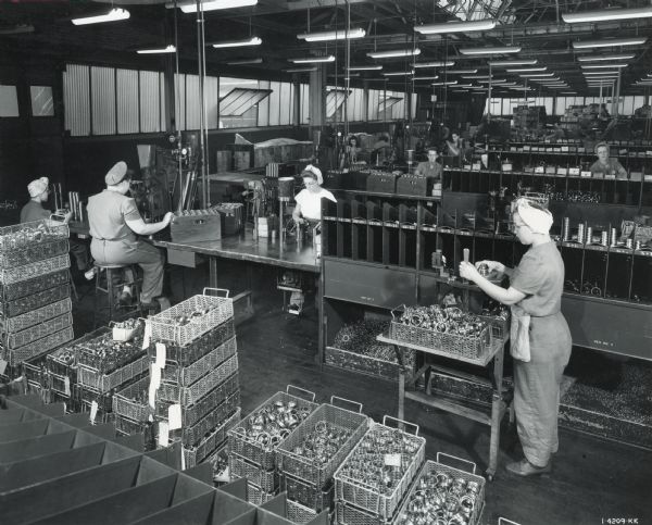 Female factory workers handle parts in the ball bearing plant at West Pullman Works.