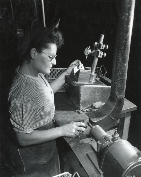 A female factory worker machines a part in the ball bearing plant at West Pullman Works.