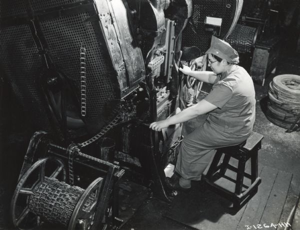 A female factory worker operating a machine at West Pullman Works.