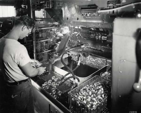 A factory worker handles metal parts at West Pullman Works.