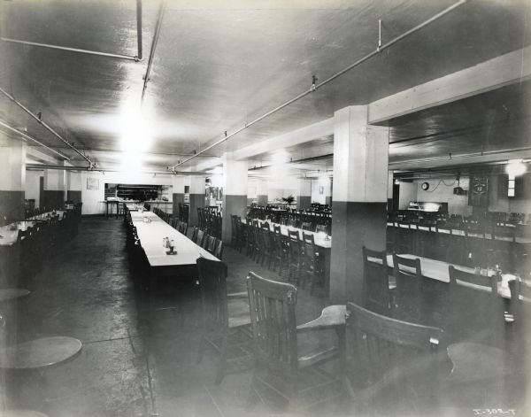 Chairs arranged around long tables in the cafeteria at International Harvester's Hamilton Works factory.