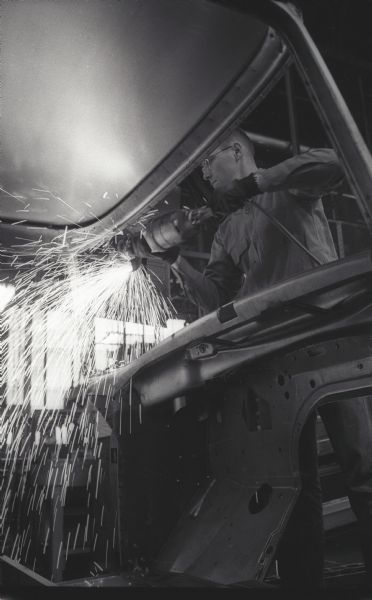 A shower of sparks fly as a factory worker tends to an International A-100 "Golden Jubilee" truck at Springfield Works.