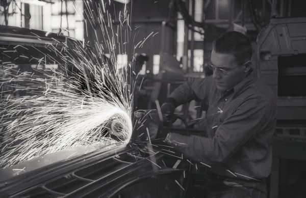 Sparks fly as a factory worker uses a tool on an International A-100 "Golden Jubilee" truck at International Harvester's Springfield Works.