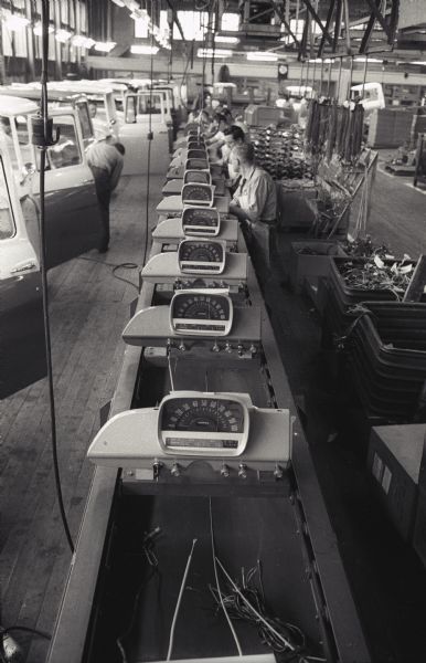 Factory workers tend to a line of dashboard consoles for International A-100 "Golden Jubilee" trucks at International Harvester's Springfield Works.