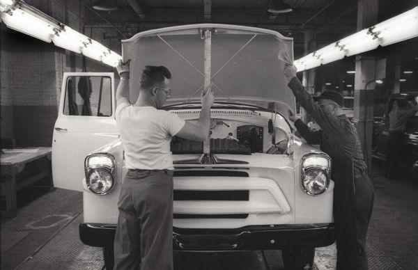 Factory workers attach a hood to an International A-100 "Golden Jubilee" truck at International Harvester's Springfield Works.