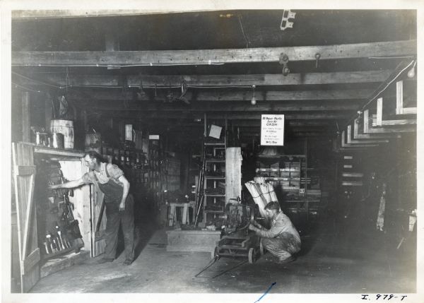 Two men work in the repair shop of Wertz S. Shaw, an International Harvester dealership.
