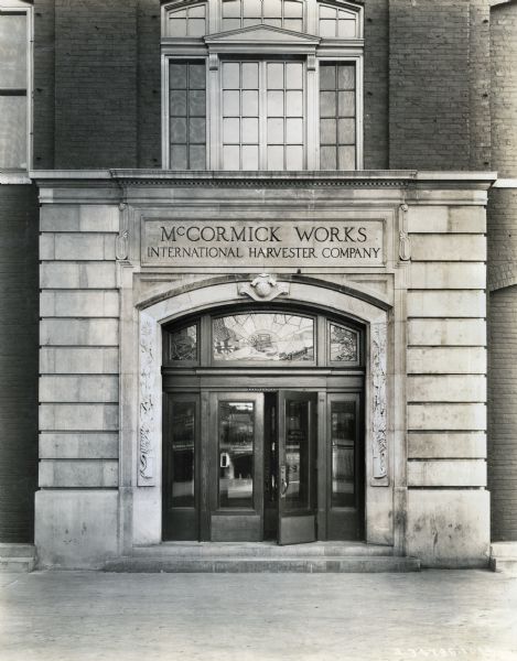 Exterior view of stained glass panels and stone reliefs which decorate the doors at the entrance of the McCormick Works factory.