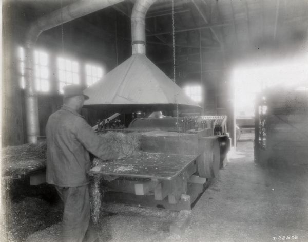 A man feeding hemp into a hemp tow machine.