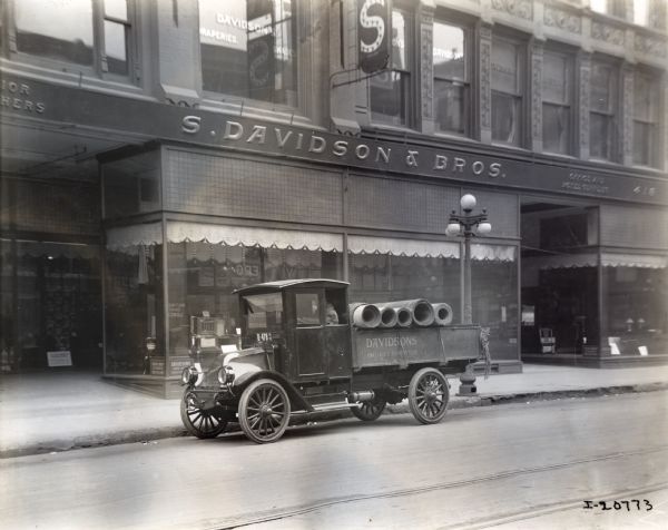 International model "F" or "31" truck operated by Davidson's, "Iowa's Largest Furniture Store". A man is driving the truck which is carrying rolls of carpeting. The truck was photographed outside of the S. Davidson and Bros. store.