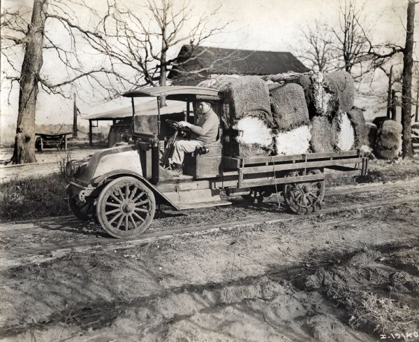 International model "F" or "31" truck loaded with cotton bales. There is a male driver in the driver's seat.
